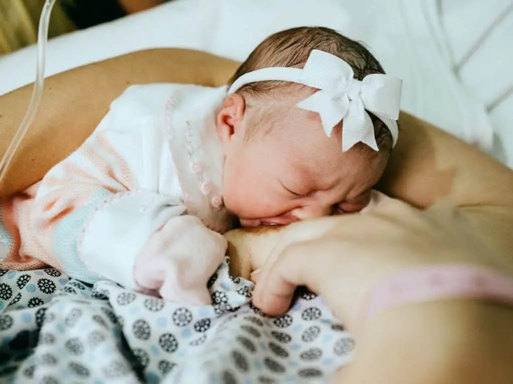 Newborn baby girl breastfeeding