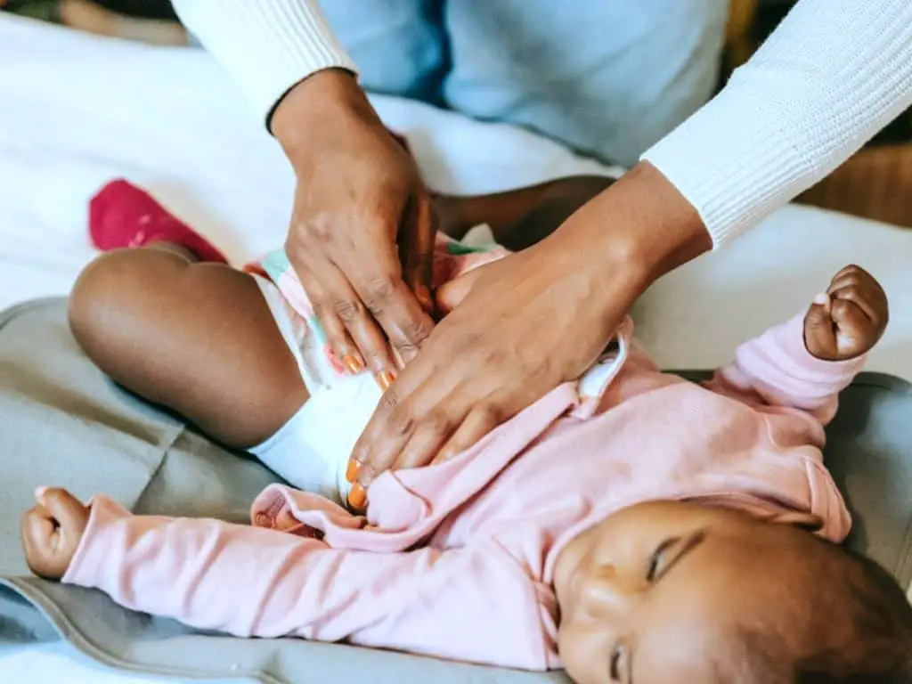 Mom changing baby on small changing table