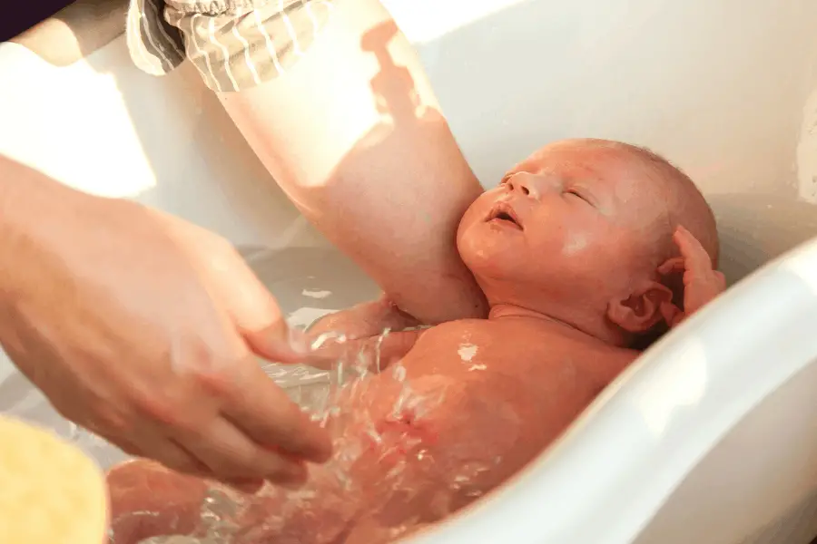 mom bathing a newborn baby at home