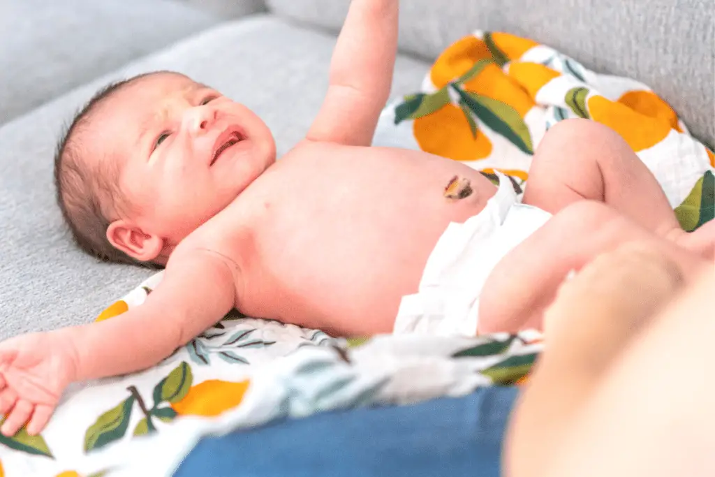 newborn baby in diaper with umbilical cord area exposed